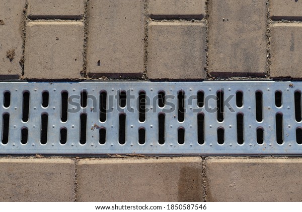 Finishing sidewalk\
on street with drainage\
grid