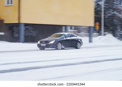 Hämeenlinna, Finland - January 9th 2022 : Black Car Speeding Along Icy And Slippery Street