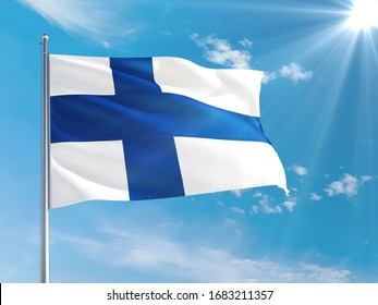 Finland national flag waving in the wind against deep blue sky. High quality fabric. International relations concept.
