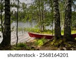 Finland, North Karelia, Joensuu. Red boat on a lake shore