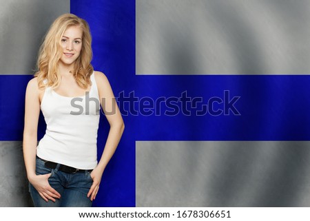 Finland. Young cute blonde happy woman with Finnish flag background