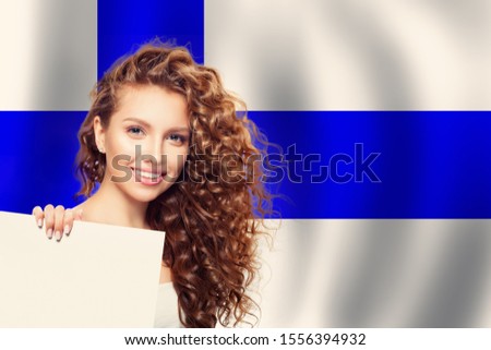 Finland. Young cute happy woman with Finnish flag background and white paper