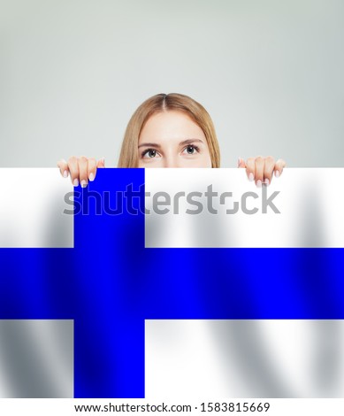 Finland. Young happy woman with the Finnish flag background