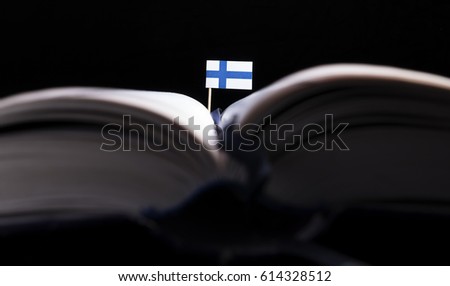 Finnish flag in the middle of the book. Knowledge and education concept.