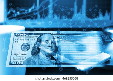 FINTECH concept , Financial and Technology. US Dollar banknotes and abstract binary code with mobile phone,coffee cup ,stock market graph laptop computer background, cryptocurrency or digital money.