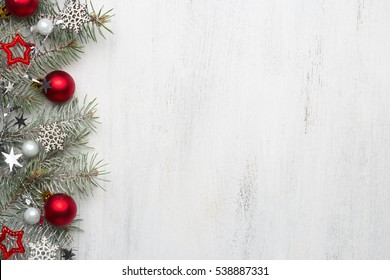 Fir branch with Christmas decorations on old wooden shabby background with copy space for text.