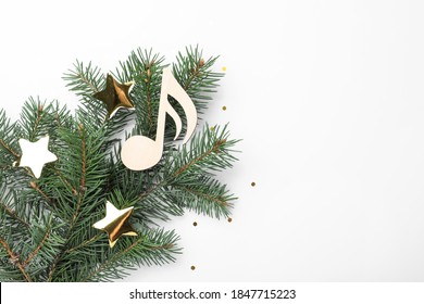 Fir Tree Branch With Decorative Golden Stars And Wooden Music Note On White Background, Top View. Christmas Celebration