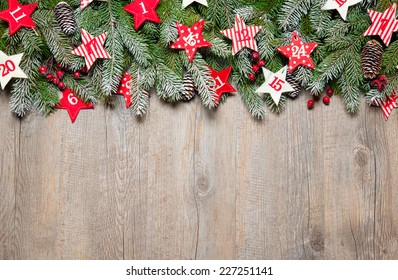 Fir tree  branches and advent calendar stars on old wooden board