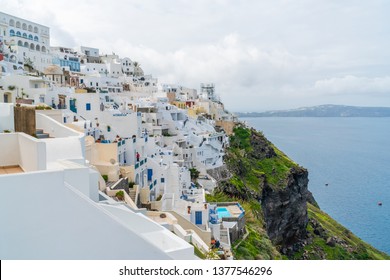 FIRA, SANTORINI - APRIL 08, 2019: Fira is the capital of Santorini, a Greek island in the Aegean Sea, located on clifftop with views of Nea Kameni, a still-active volcanic island.