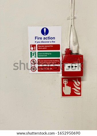 Fire action plan sign and manual fire alarm point in public work place