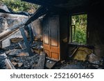 Fire aftermath. Burnt wooden house interior with remnant of furniture.