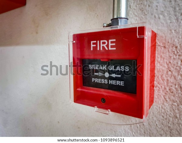 Fire alarm box on white wall for warning and security system.