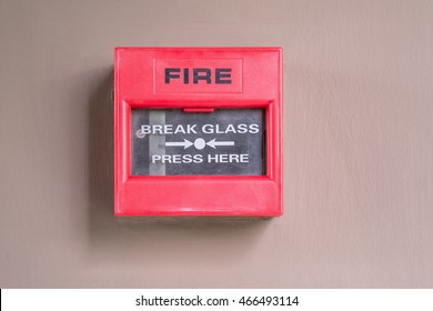 Fire alarm button on light brown cement wall