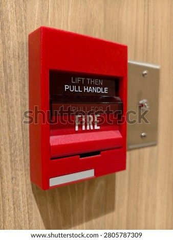 Fire alarm pull station on wooden wall