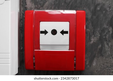 Fire alarm push button on grey wall