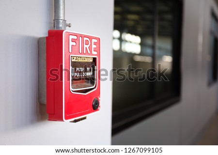 Fire alarm switch on the factory wall.