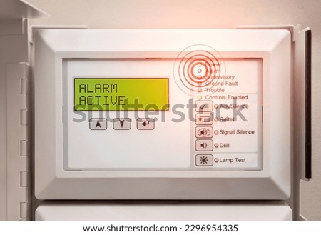 Fire alarm system with active alert.  Evacuation alarm display. Control panel with alarm active message and flashing red lights. Fire panel in service room of residential and commercial building. 