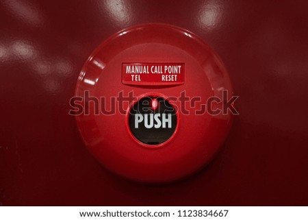 fire alarm system button on red wall