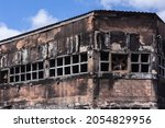 Fire arson factory warehouse building burned damaged close-up detail economy business industry unemployment poltical atmosphere.