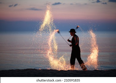 Fire art festival on the sea; dancer spinning poi