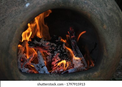Fire blazing in an earthenware chimnea.