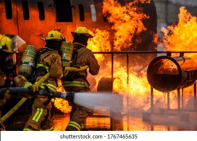 Fire brigade people extinguishing the fire, Fire brigade spreading water, Fire man fighting, Water pipes in hands, in New York, USA on 25th June 2020