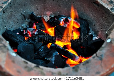Fire burning charcoal in stove.