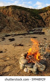 Fire for cooking on a beach with selective focus and copy space.