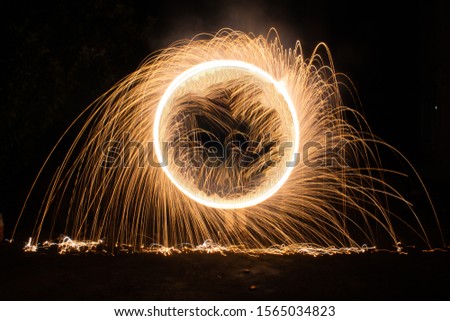 A fire cracker turned along a circle path . And the trail was captured with a slow shutterspeed