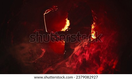 Fire dance. Body performance. Sensual artistic woman silhouette moving in red magic flame smoke in bright spot light on dark background copy space.