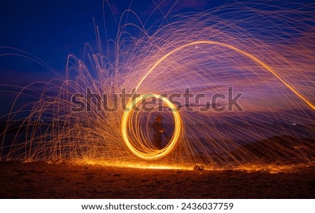 Fire dancer swing fire dancing show on celebration with dark sky background.