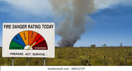 Fire Danger Rating Display Board Set To Extreme In Front Of Bushfire. Image Taken In Queensland, Australia.