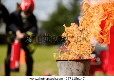 Fire Drill Training. Firefighters practice controlling an outdoor fire with extinguishers