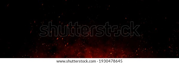 Fire embers particles over black background. Fire\
sparks background. Abstract dark glitter fire particles lights.\
bonfire in motion blur.