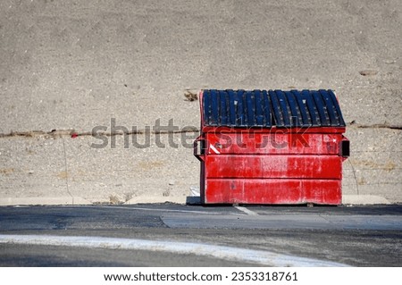 Fire engine red dumpster sitting alone in the California desert