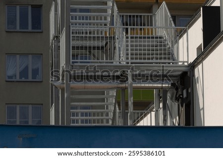 A fire escape is currently under construction on the side of a multistory building, ensuring safety and accessibility for residents and visitors