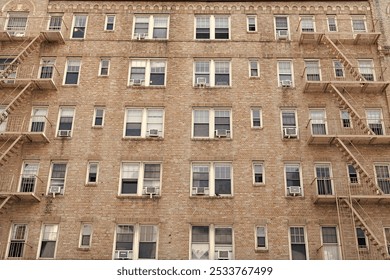 Fire escape on a building. Fire escape ladder. Detail view of an old building with a brick wall facade and an iron fire escape. Fire Escape stairs on the building wall. Residential building - Powered by Shutterstock