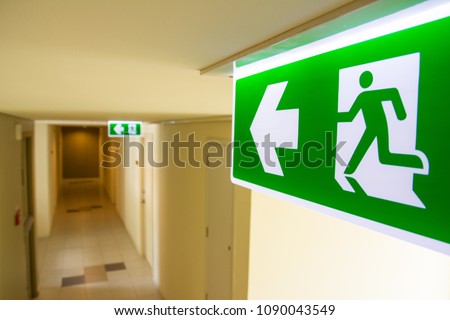 Fire exit sign at  the corridor in building