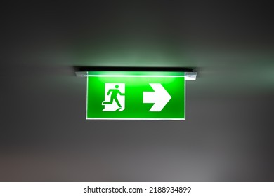 Fire Exit Sign Light Box Is Hung On The Ceiling In Hotel Walk Way.