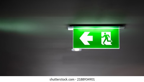 Fire Exit Sign Light Box Is Hung On The Ceiling In Hotel Walk Way.