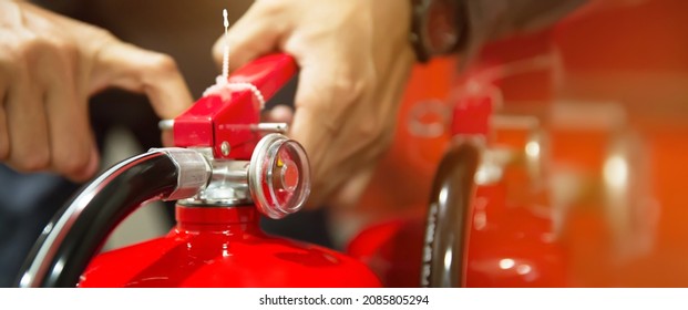 Fire extinguisher, Hand of engineer pull safety pin to using fire extinguisher tank of protection and prevent emergency and rescue or fire alarm system training.