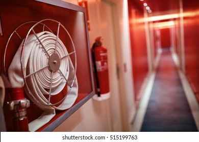 Extintor de incendios y carrete de manguera de incendios en el pasillo del hotel