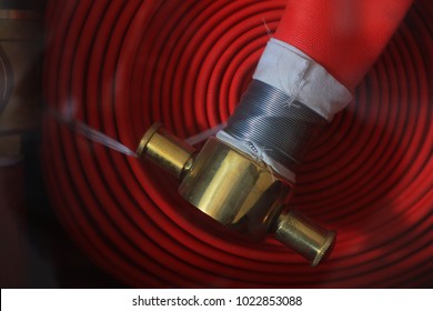 Fire extinguisher and fire hose reel.Red fire hose in the reel.selective focus.
