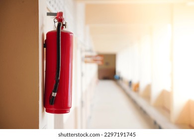 Fire extinguishers are mounted on a corridor on the wall.