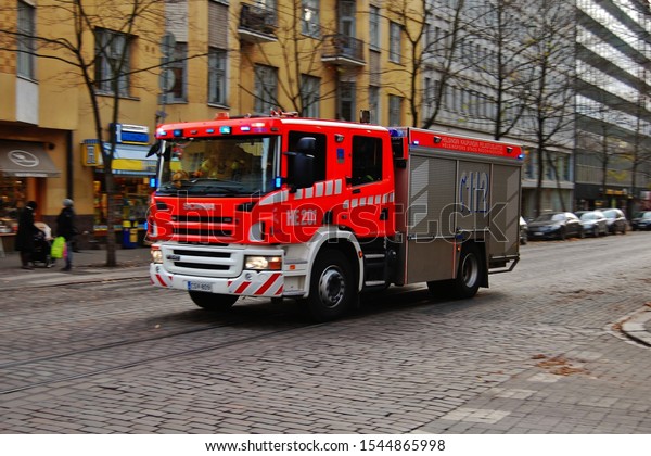 Fire fighter\
truck (fire engine) racing to the fire at the Helsinki street.\
Helsinki, Finland, October 27,\
2012.