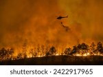 Fire fighting helicopter carry water bucket to extinguish the forest fire.