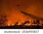 Fire fighting helicopter carry water bucket to extinguish the forest fire.