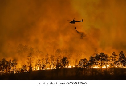 Fire fighting helicopter carry water bucket to extinguish the forest fire.