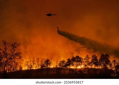 Fire fighting helicopter carry water bucket to extinguish the forest fire.