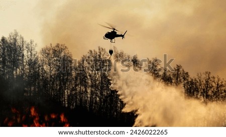 Fire fighting helicopter carry water bucket to extinguish the fo